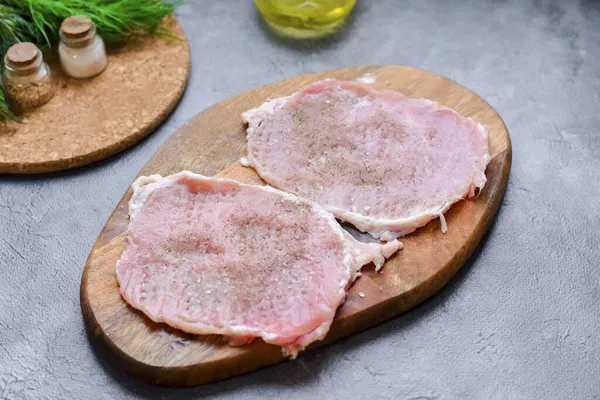 Cut the pork into plates, cover with cling film, then beat off with a kitchen hammer. Season the meat with salt and pepper to taste.