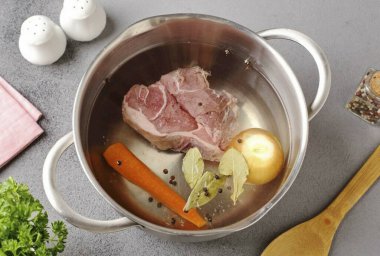 Tencereye su dök, et, soğan ve tam havuç, biber ve defne yaprağı ekle. Kaynamayı bekle, köpüğü çıkar ve et tamamen pişene kadar pişir..