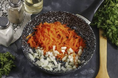 Soğanları küçük küplere ayır ve havuçları ince hücrelerle rendele. Her şeyi tavada ısıtılmış sebze yağıyla altın kahverengiye kadar 4-5 dakika geçirin..