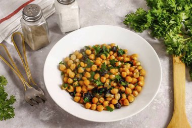 Nohutları kuru erikle birlikte kaselere koy ve ayrı bir tabak ya da meze olarak servis et..