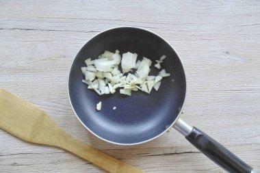 Soğan ve sarımsağı soy, yıka, güzelce doğra ve tavaya yerleştir..