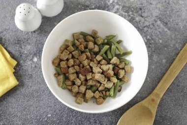 Fasulyeleri derin bir kaseye aktarın ve kızarmış ekleyin. Herhangi bir tadı olan 