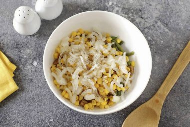 Soğanı tüy ya da küp yapın, kaynar suyla kaynatın ve kalan malzemeleri de ekleyin. Tuzlu ve biberli salatanın tadına bak..