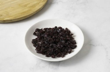 Kurutulmuş kızılcıkları ince ince doğra..