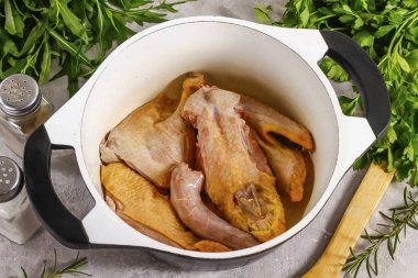 Kazanda sebze yağı ısıt ve ördek parçalarını içine koy. Orta sıcaklıkta kızarana kadar yaklaşık 10 dakika kızaracak. Sonra sıcak su dökün, körfez yaprakları ekleyin ve su neredeyse tamamen buharlaşana kadar yaklaşık 1-1.5 saat boyunca her şeyi kaynatın.