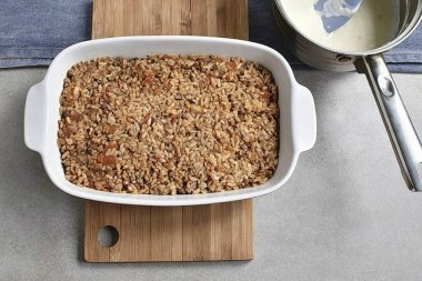 Üstünde kıyma ve pirinç karışımı var. Yüzeyi düzleştir.