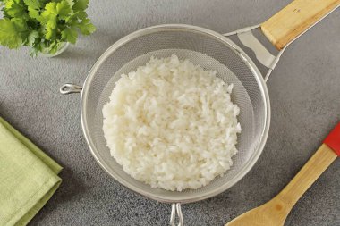 Pirinci durula ve 10 dakika tuzlu suda haşla. Sonra elek üzerine katla ki tüm su cam olsun..