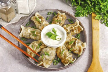 Ekşi kremayla ya da diğer soslarla sıcak servis et, üzerine doğranmış yeşil soğan serp..