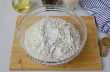 Un ve tuzu büyük bir kuru kasede birleştir. Karıştır.