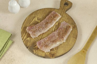 Domuzu porsiyonlara böl, her iki tarafı da hafifçe döv, tuz ve baharatla ovala..