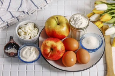 Elmalı Pofuduk Turtası yapmak için gereken tüm malzemeleri hazırlayın. Elmalar her türlüsü olabilir. Meyve ekşiyse, şeker ekle..