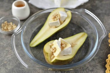 Camembert peynirine çam fıstığı serpin ve küfü fırına koyun 15 dakika boyunca en üst seviyede 200 dereceye kadar ısıtın..
