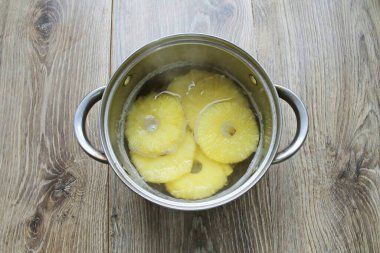 Yüzükleri şurup tenceresine koy ve ananasları kaynattıktan sonra 10 dakika boyunca kaynat..