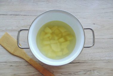 Çorbayı tencereye dök. Patatesleri soy, durula ve doğra. Çorbalı bir tencereye koy..