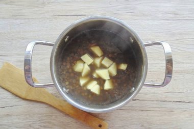 Patatesleri soy, durula, kes ve mercimek tenceresine ekle..