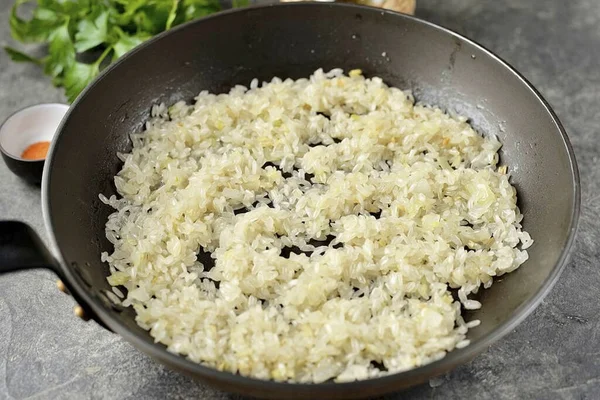 ニンニクが油にすべての味を与えているとき それを破棄 鍋にご飯を入れてください 数分間香り油で米を炒める それは透明になり すべての香りを吸収する必要があります — ストック写真