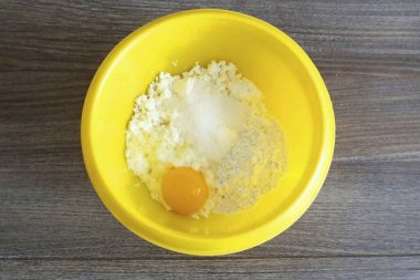 Doldur şunu. Süzme peynir, ekşi krema, yumurta, tuz ve şekeri kasede birleştirin. Karıştır.
