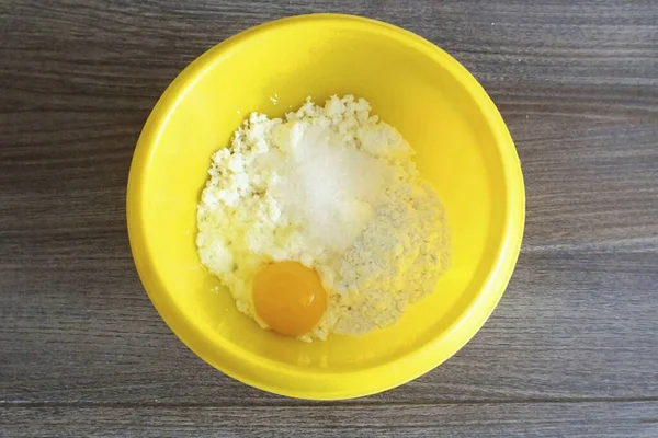Doldur şunu. Süzme peynir, ekşi krema, yumurta, tuz ve şekeri kasede birleştirin. Karıştır.
