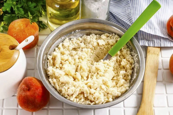 Rub the entire contents of the container together with a fork, creating sand crumbs. Place it in the refrigerator for 20 minutes.