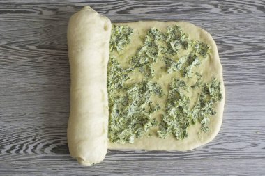 Dar kısımda yuvarlan. Her dönüşten sonra, hamuru katmana bağla..