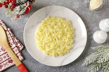 Kabaca rendelenmiş patatesleri ilk tabağa koy. Her katmanı ince bir katman mayonezle yağla, tadı için tuz ve biber ekle..