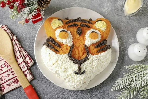 Ayrıca rendelenmiş zeytin, şerit (gelecekteki kaplanın rengi) ve geri kalan sarıları kullanarak kulakların içini uzatın..