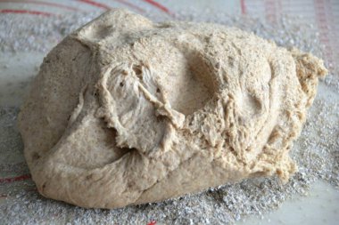 Masanın iş yüzeyini hafifçe un, kepek ya da her ikisinin karışımı ile serpin, hamuru bırakın, daha fazla yoğurmayın, sadece hamuru bir tabaka içine uzatın..