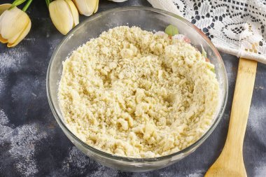 Yağı 5-10 dakikalığına dondurucuya koy. Buğday ununu derin bir kaseye dökerek, hamuru yuvarlamak için yaklaşık 70-80 gram bırakır. Una tuz ve 20 gram granüle şeker ekle. Kaba bir rendeleyicinin tereyağını rendele ve iyice karıştır.