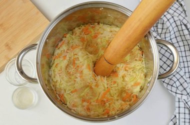 Büyük bir tencere al, lahana ile havucu karıştır, dereotu ve tuzu karıştır. Unutma lahana, ellerinle ya da kullanışlı herhangi bir nesneyle bunu merdaneyle yapıyorum ki suyu çıkarsın..