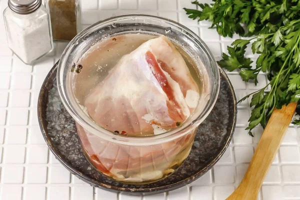 水で肉をすすいで 肌をこすり 容器に入れ それが完全にブラインで覆われるようにします 肉が浮くと抑圧を加えることができます 3日間冷蔵庫に容器を置きます 数回肉をオンにします — ストック写真