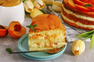 Pastayı buzdolabından çıkar. Formu kaldır. Şeftali dilimli garnitür ve porsiyonlar halinde kesilmiş. Soğuk servis et..