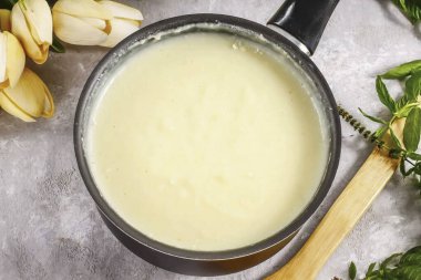 Konteynırı ocağın üzerine koy ve kremayı 12-15 dakika kadar kaynatıp karıştırmayı unutma. Kalın olduğunda, tereyağını karıştır ve ısıyı kapat. Merak etme, krem soğudukça tekrar kalınlaşacak. 40-60 dakika sakinleş. 