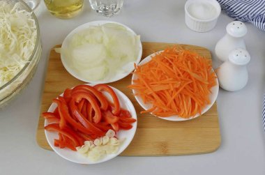 Soğan soy, havuç, sarımsak, dolma biberden tohum ayır. Soğan ve biberi ince ince doğra, sarımsağı dilimle. Kaba rende havuçları rendele (Kare rende kullanıyorum).