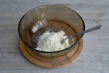 Kuru karışımın yarısını bir kase suya boşalt, karıştır. Unun diğer yarısını ekle, hamuru yoğur..