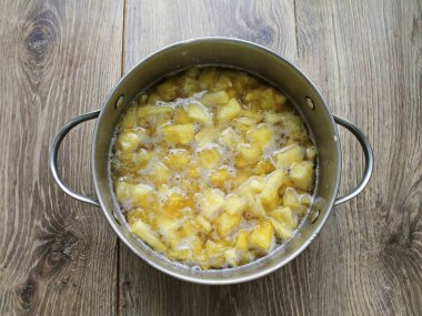 Soyulmuş ananası parçalara ayır ve paslanmaz çelik bir kaba koy. Ananasa şeker ekle, karıştır ve 12 saat boyunca soğutma yap..