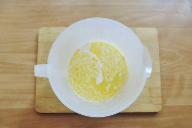 Ilık süt, erimiş ve hafif soğutulmuş tereyağı ve bir kaşık şeker ekle. Mayanın aktive olmasına izin ver..