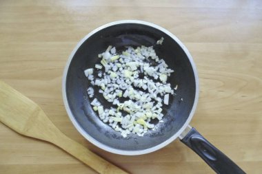 Hamur dinlenirken, kiş için dolguyu hazırla. Soğanları soy, yıka ve güzelce doğra. Sebze yağıyla tavaya koy ve kızart..