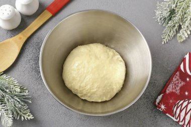 Hamur plastik olmalı, ama eline biraz yapışkan. Bir topta toplayın, yağla fırçalayın, bir kâseye koyun, yapışkan filmle kaplayın ve yaklaşık 1,5 saat boyunca sıcak bir yerde bırakın. Boyutu artmalı..