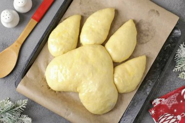 Ve şimdi en önemli görev! İş parçalarını kaplan pençesi şeklinde parşömenle kaplanmış bir kabın üzerine dikmek gereklidir. Çoğunu ilk sıraya koyuyoruz ve istediğimiz şekli vermek için ellerimizi kullanıyoruz. Hamur çok yavan.