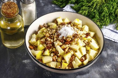Elindeki ceviz çekirdeklerini kır. Arzu edilirse tavada kızartılıp soğutulabilirler. Fındık kırıntılarını kabın içine dök, tuz ve karabiber ekle..