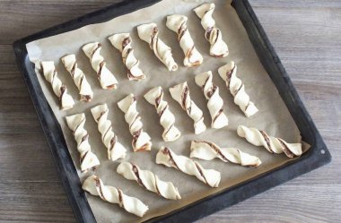 Pişirme kağıdıyla bir çarşaf doldur. Hamur parçalarını ayır. Fırını 180 dereceye 20-25 dakika ısıtın..