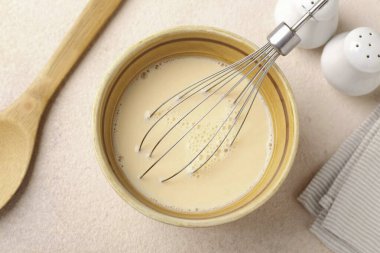 Süt ve yumurtayı birleştir. Tuz, biber ve çırpma mevsimi.