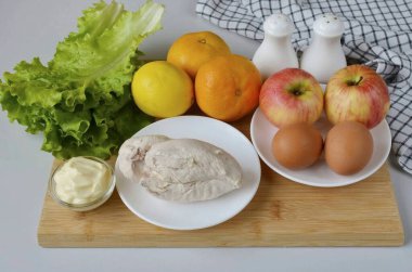 Mandalina salatası yapmak için gereken tüm malzemeleri hazırlayın. Haşla ya da fileto pişir, buzdolabına koy. Yumurtaları kaynatın, soğutun ve kabuğunu çıkarın..