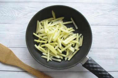 Peel, wash and cut the potatoes into cubes. Can be cut into slices, but not thick. Place in a skillet.