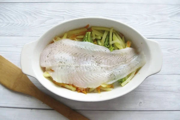 Wash the sole fillet, pat dry with a paper towel. Season with salt and pepper on both sides and place on top of the vegetables.