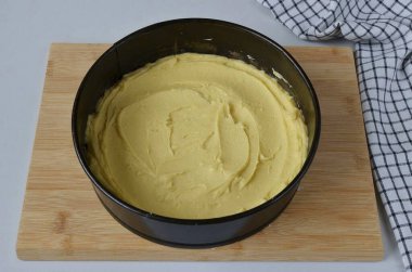 Turn the oven on to preheat. Line the baking pan with parchment. Distribute the dough with the back of a spoon, forming small rims.