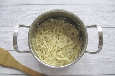 Put the spaghetti in boiling salted water and cook until half cooked. Drain the water. clipart