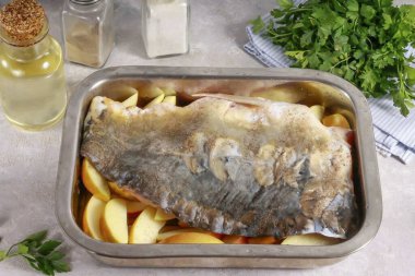 Squeeze the juice out of the lemon and mix with salt and ground black pepper. Spread over the carp fillets and place the skin on top of the apple slices. Preheat the oven to 200 degrees.