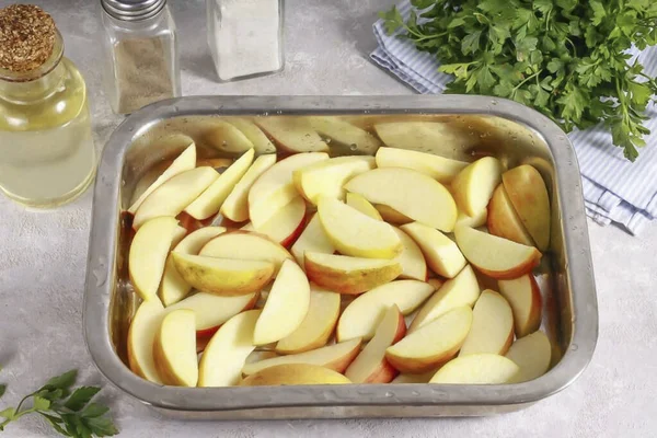 Cut the apples into quarters and cut off the seed blocks. Rinse and cut into wedges. Grease a baking dish with vegetable oil and place the apple slices in it.