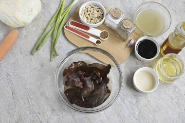 Soak Chinese mushrooms in warm water for 10 minutes. They will increase significantly in size and become pliable. Rinse, cut off the roots, if available, dry and cut into strips.